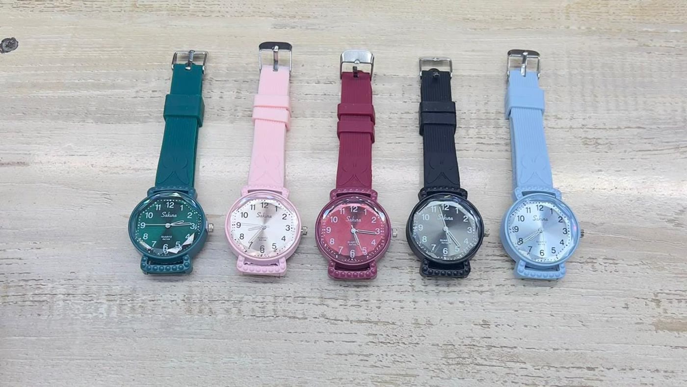 Five colourful silicone strap watches laid out in a row